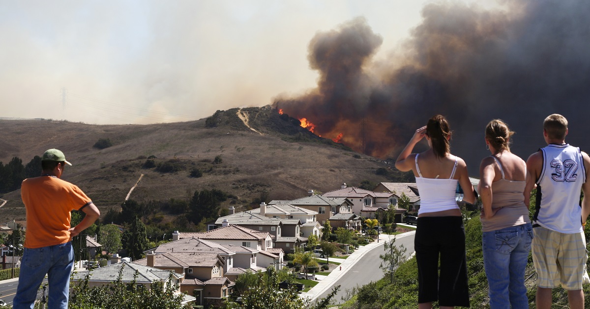 People watching fire threatening neighborhood