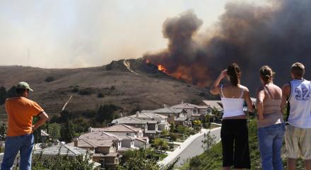 People watching fire threatening neighborhood